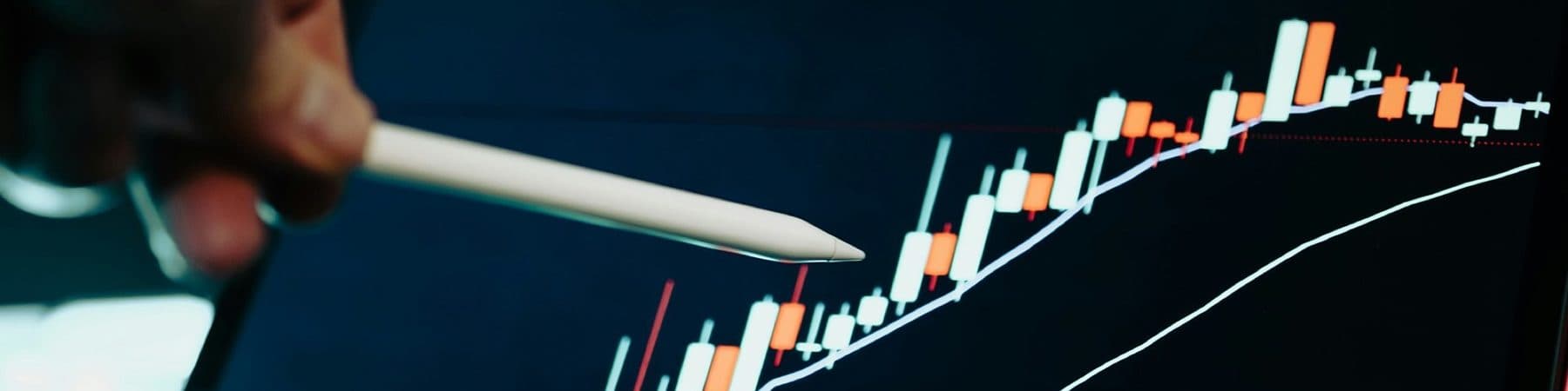A hand pointing a stylus at a business growth chart on a tablet screen